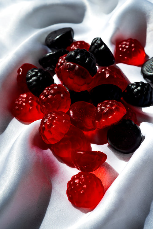 red and blue candy in the shape of berries on white silk