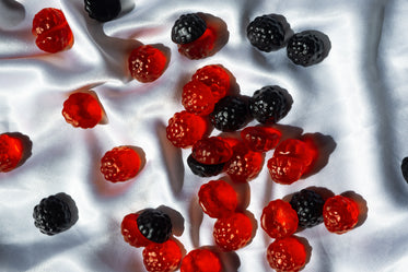 red and blue gummies lay on a white silk fabric