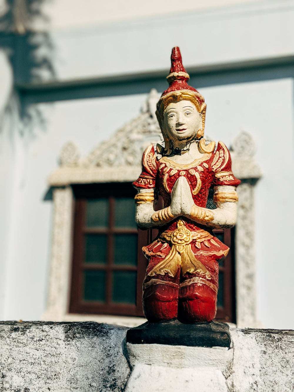 red and gold statue of a person praying