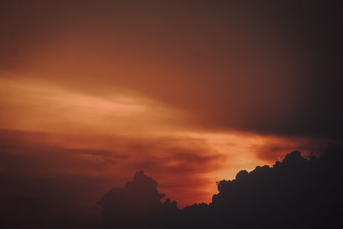 red and orange sky at sunset silhouetting clouds