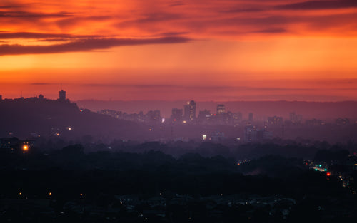red and purple sunset over hazy city