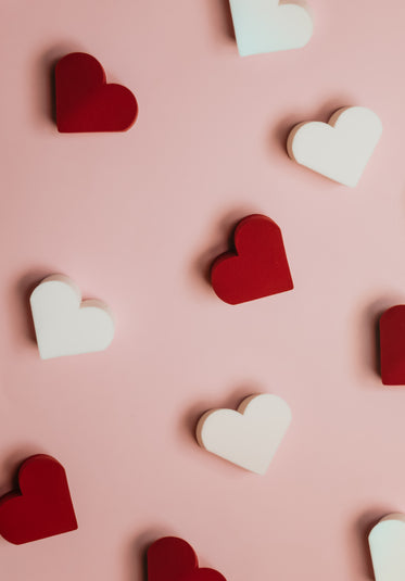 red and white hearts scattered on pink surface