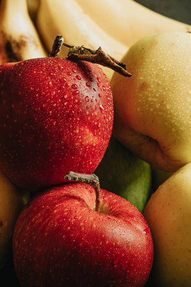 red and yellow apples covered with water droplets