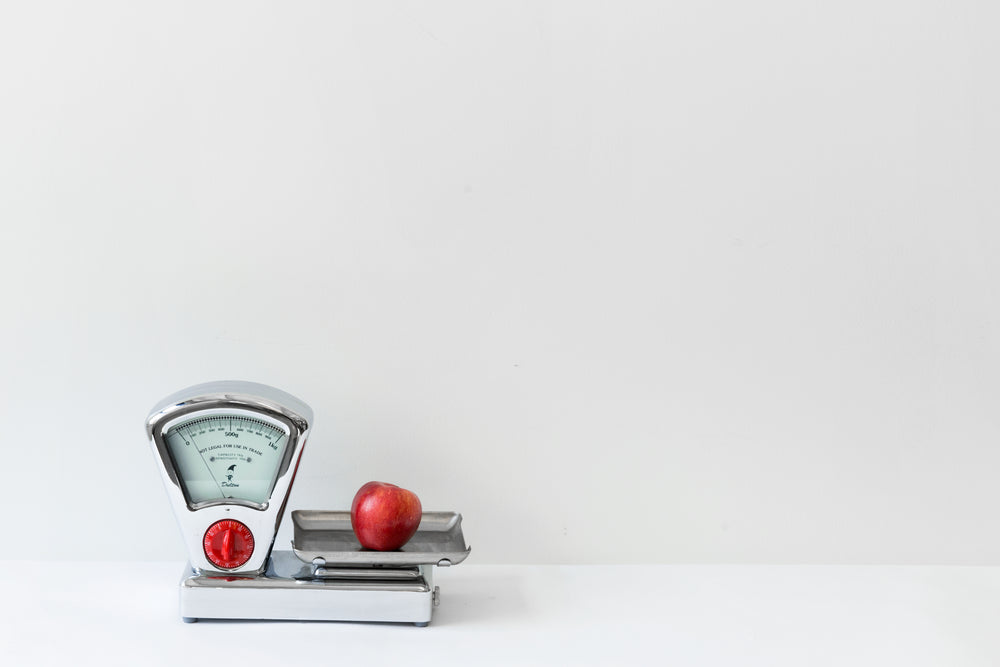 red apple on old fashioned weighing scales