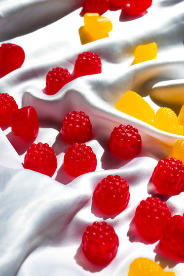 red berry shaped candy on white silk fabric