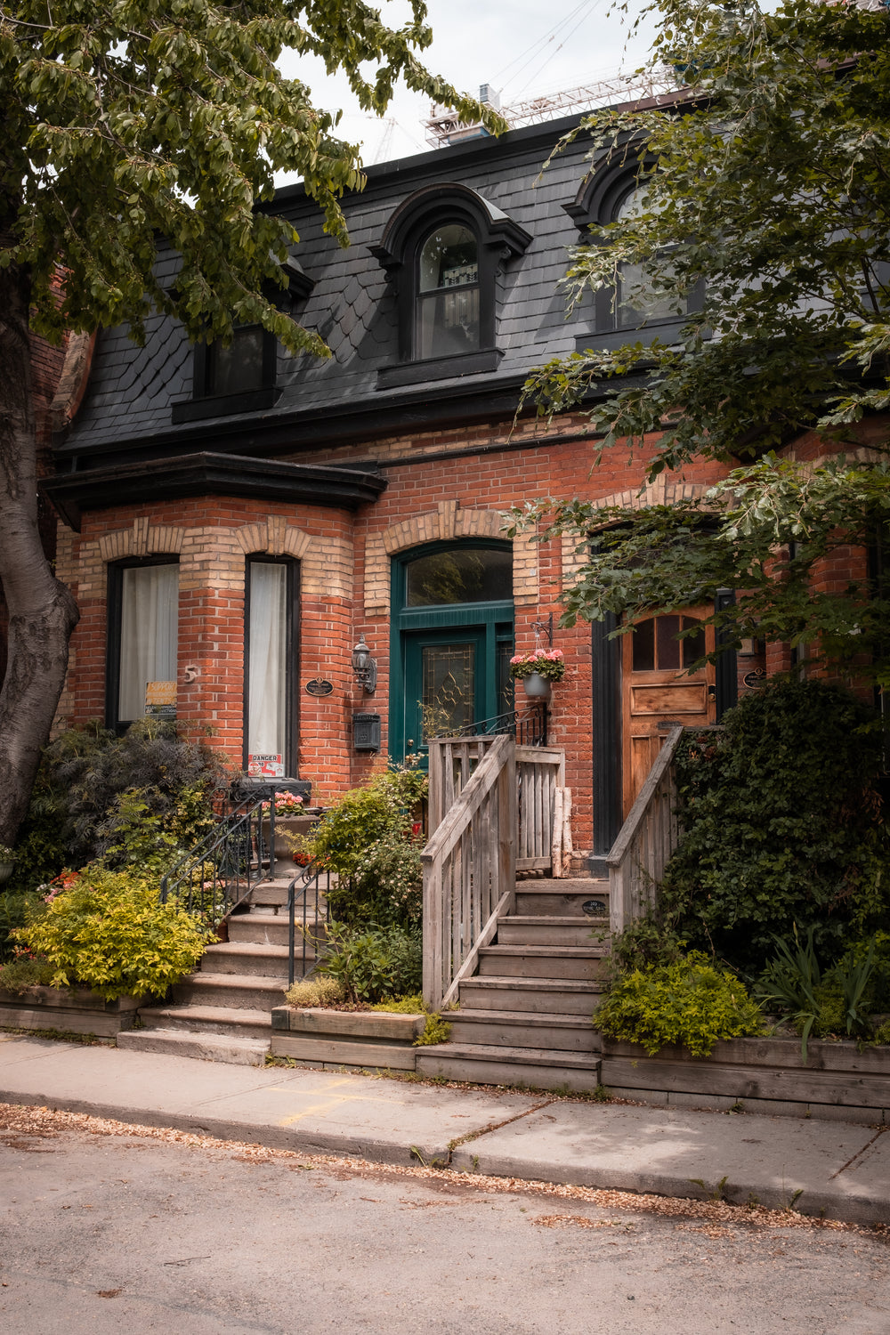 red brick house in the summer surrounded by green foliage