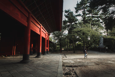 red building and trees with a person walking