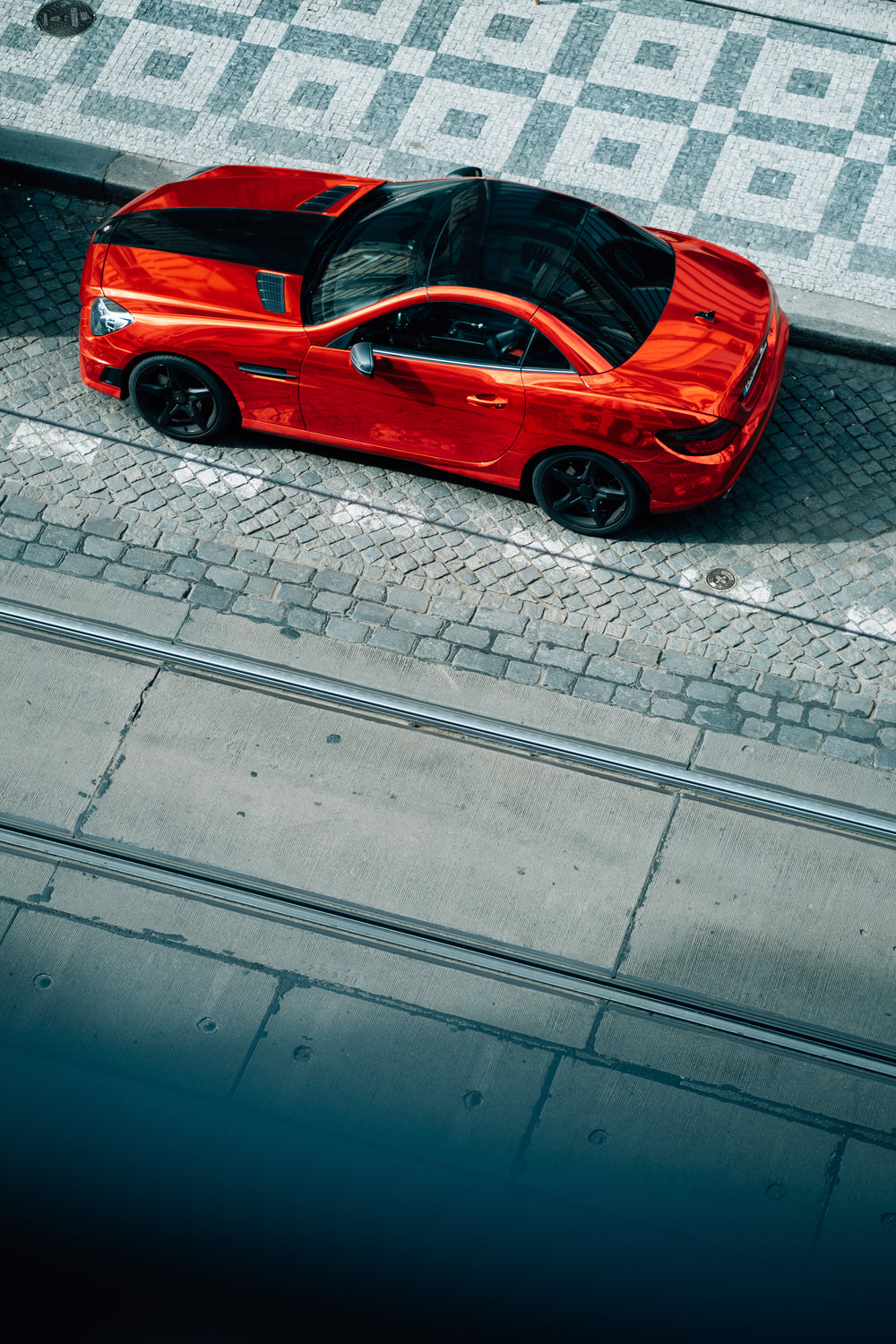 red car with a black roof parked on the side of a road