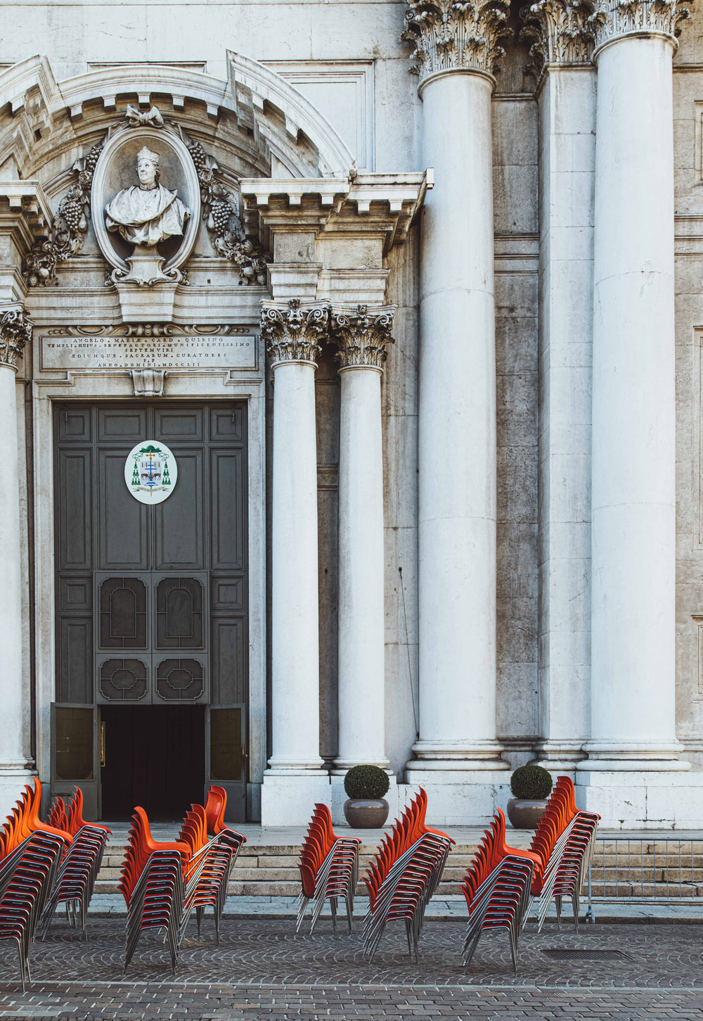 red chairs stacked outside a white regal building