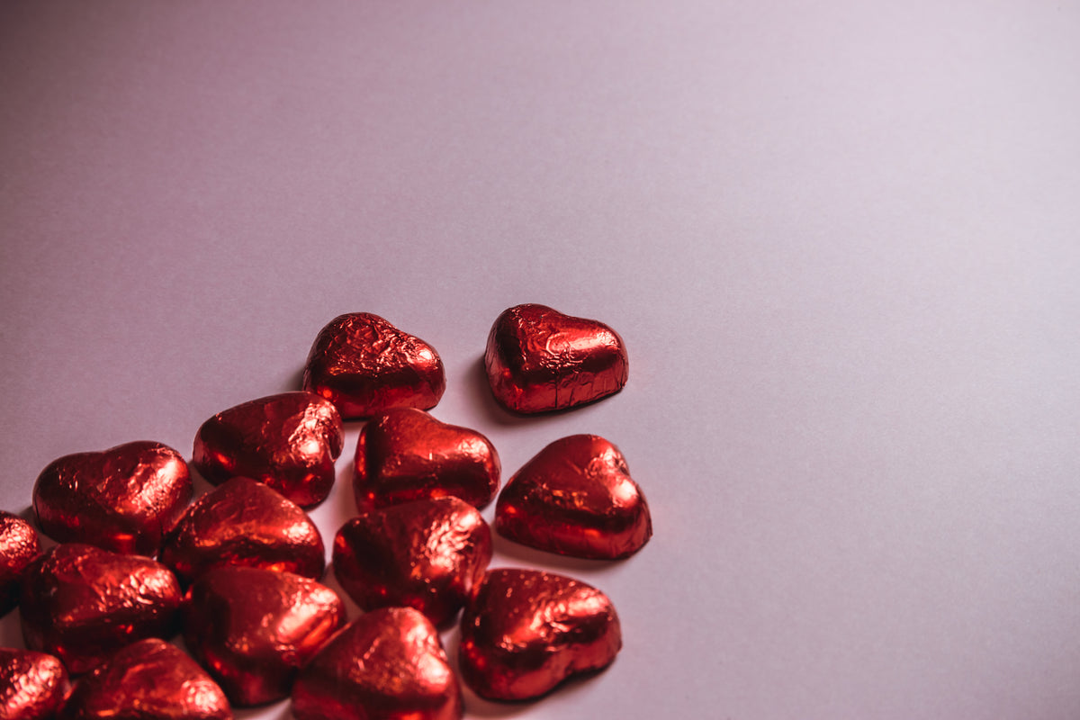 red foiled chocolate hearts against a pink background
