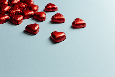 red foiled hearts lay on a light blue background