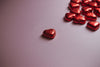 red foiled hearts on a pink background