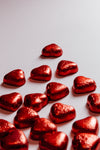 red foiled hearts scattered on a white background