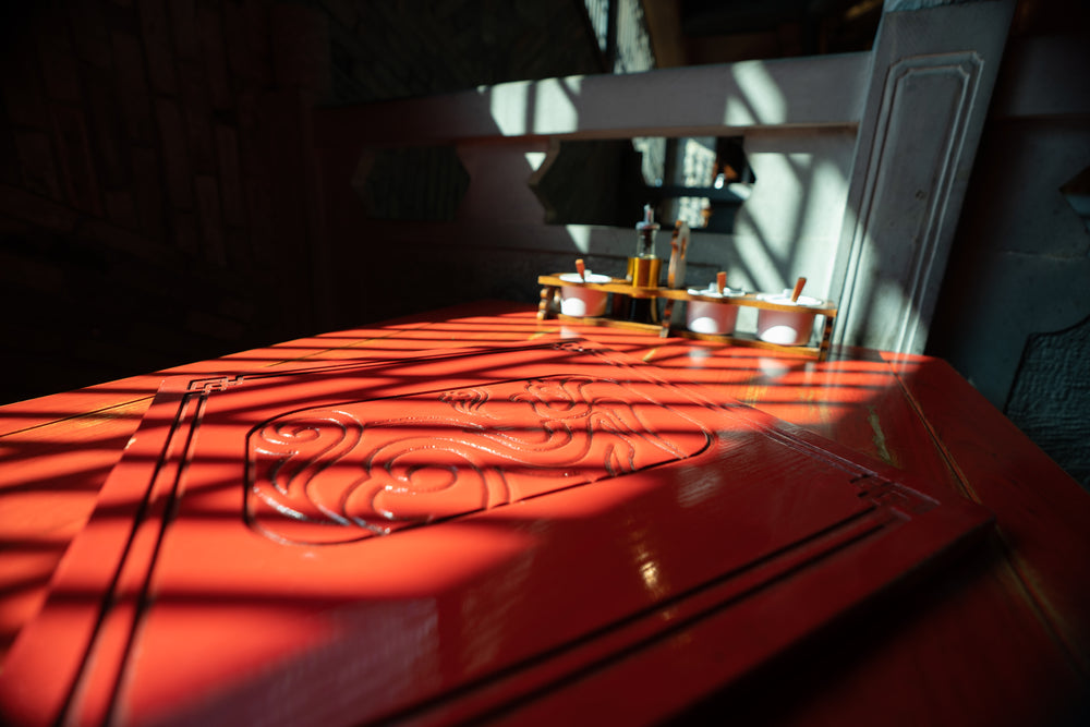 red table with carved inlay is bathed in sunlight