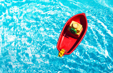 red toy boat in a swimming pool