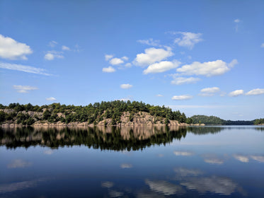 reflection of rocks and trees on lake