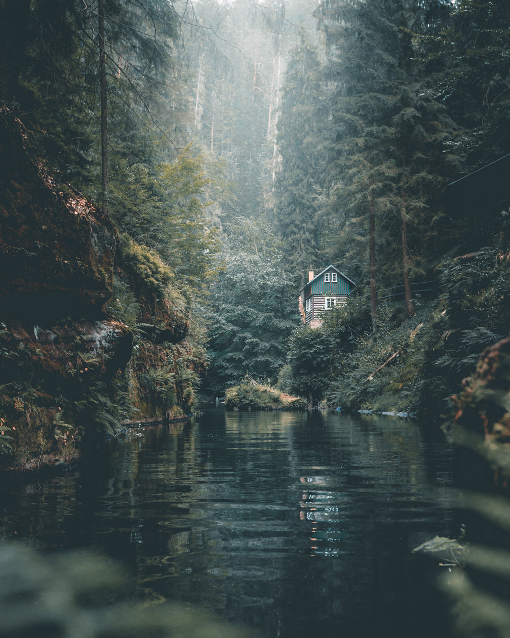 remote log cabin on calm forest river