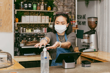 retail staff sanitizing her hands