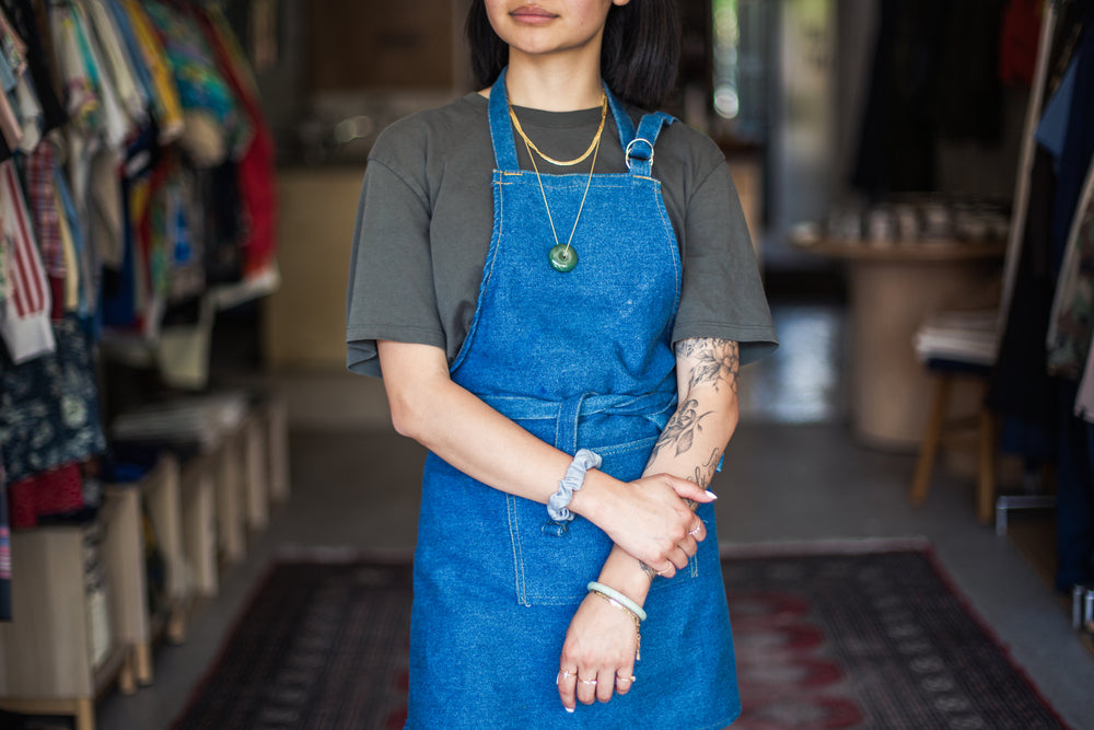 retail store owner wearing denim apron