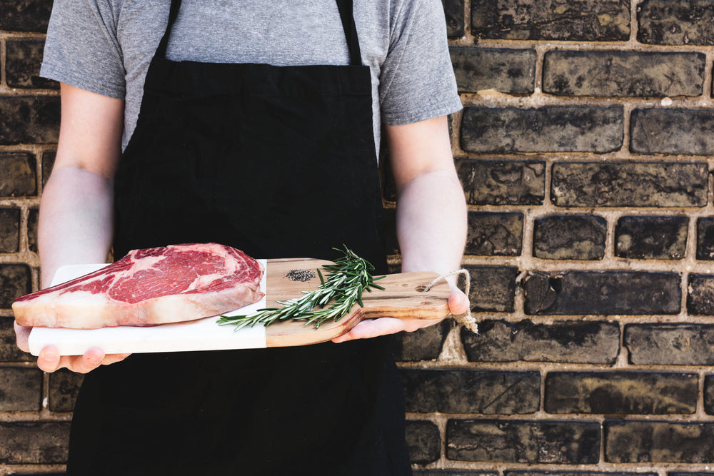 rib eye steak in chefs hands