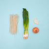 rice noodles and onions against a light blue background