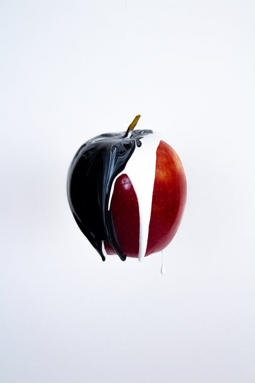 ripe red apple with black and white paint