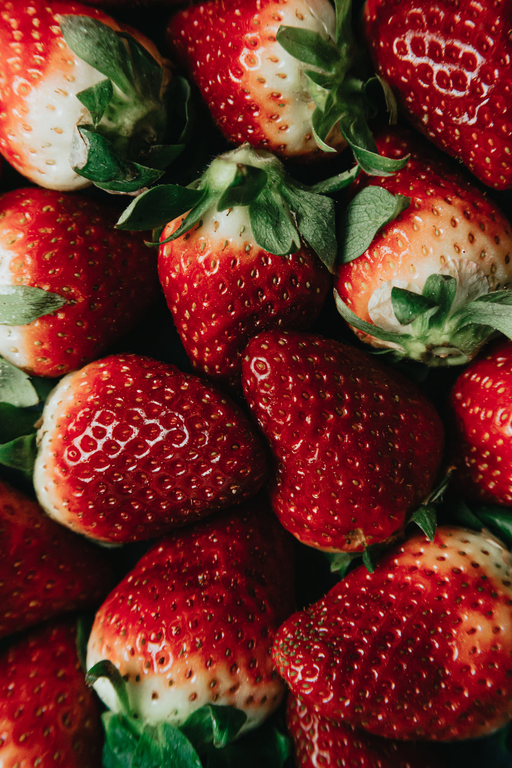 ripe red strawberries fill a frame