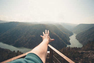 river and hills with a hand reaching outwards