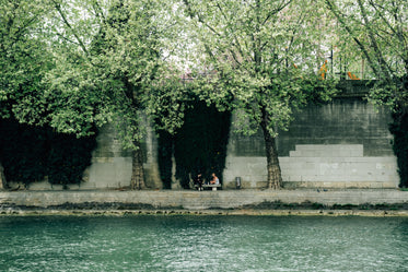 river with people sitting on the other side on a bench