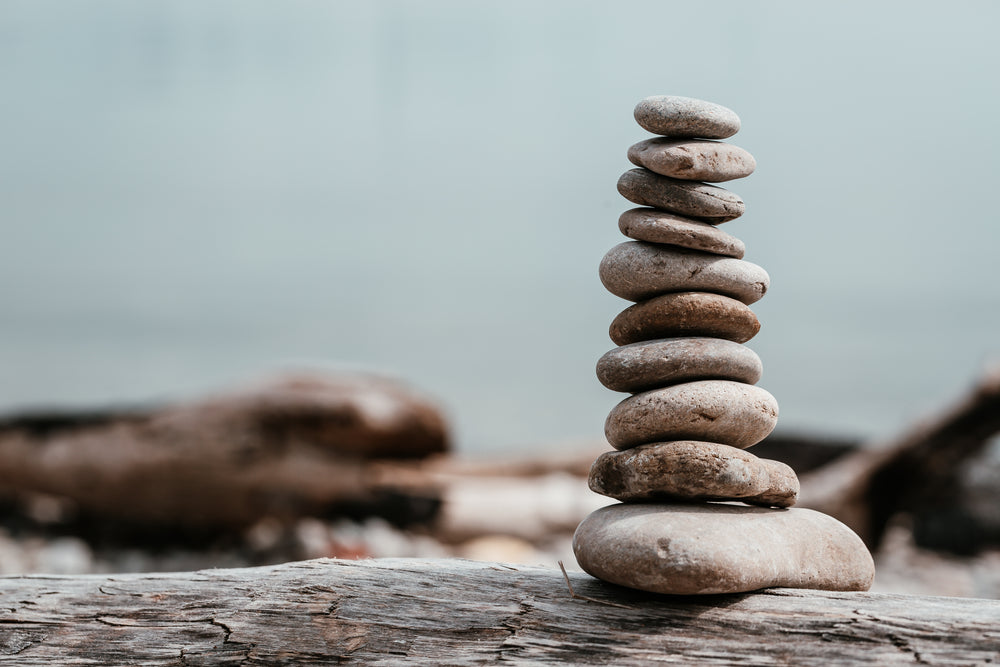 rock stack on log by water