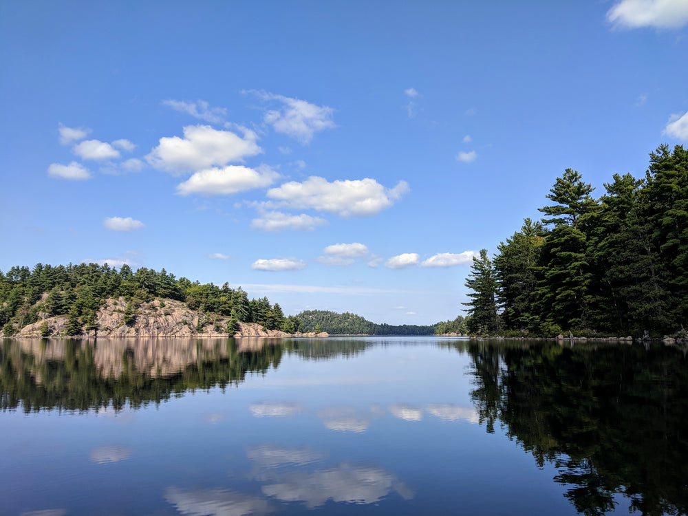 rocks and trees reflected on the calm lake