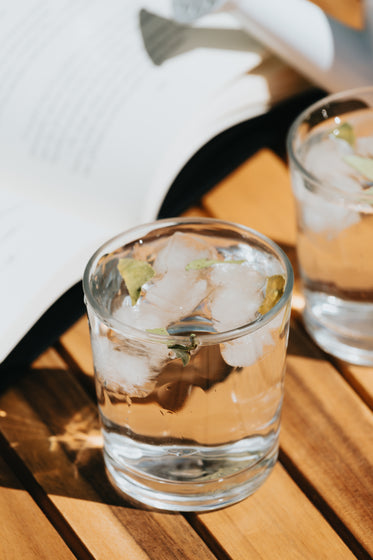 rocks glass with ice and water on a wooden table