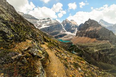 rocky mountain path leading to a lake in a valley