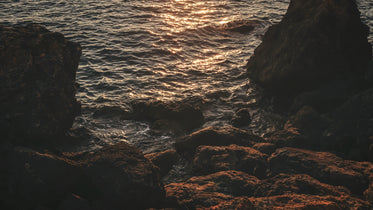 rocky shoreline lit by orange sunset