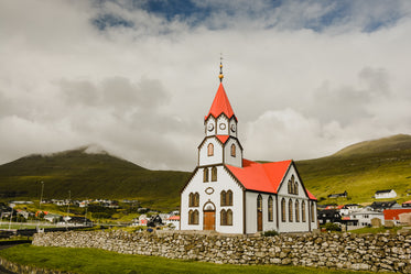 rolling green hills surround the church of sandavagur