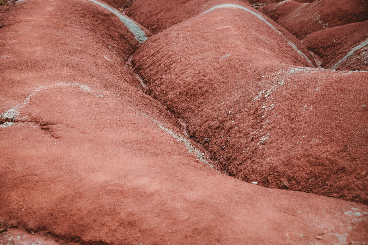 rolling shapes of red soil in badlands