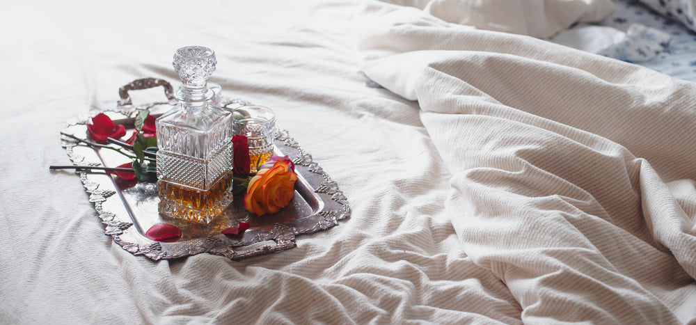 roses on a silver tray sit upon a bed