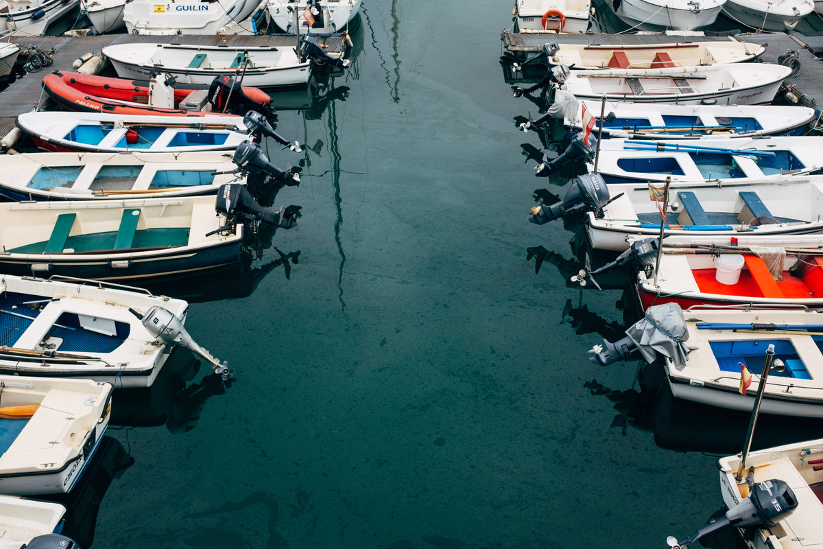 rows of boats in a marina in oily blue water