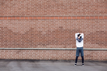 runner stretching by brick wall