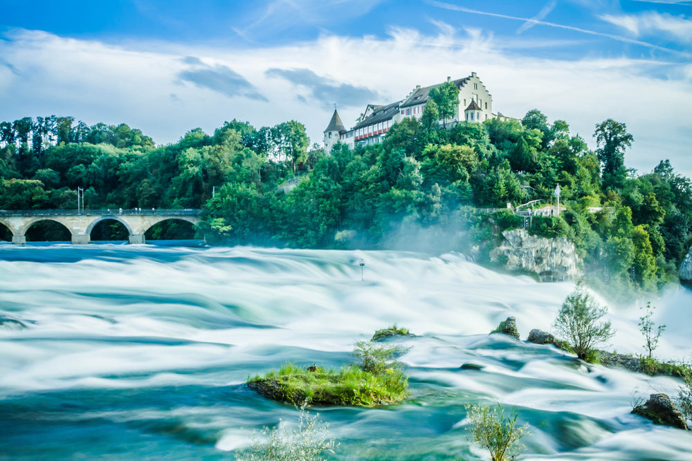 rushing water and rapids beside modern castle