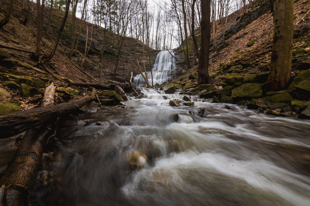 rushing water flows quickly away from cascading waterfalls