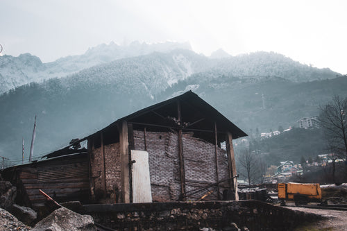 rustic building with snow capped mountains behind it