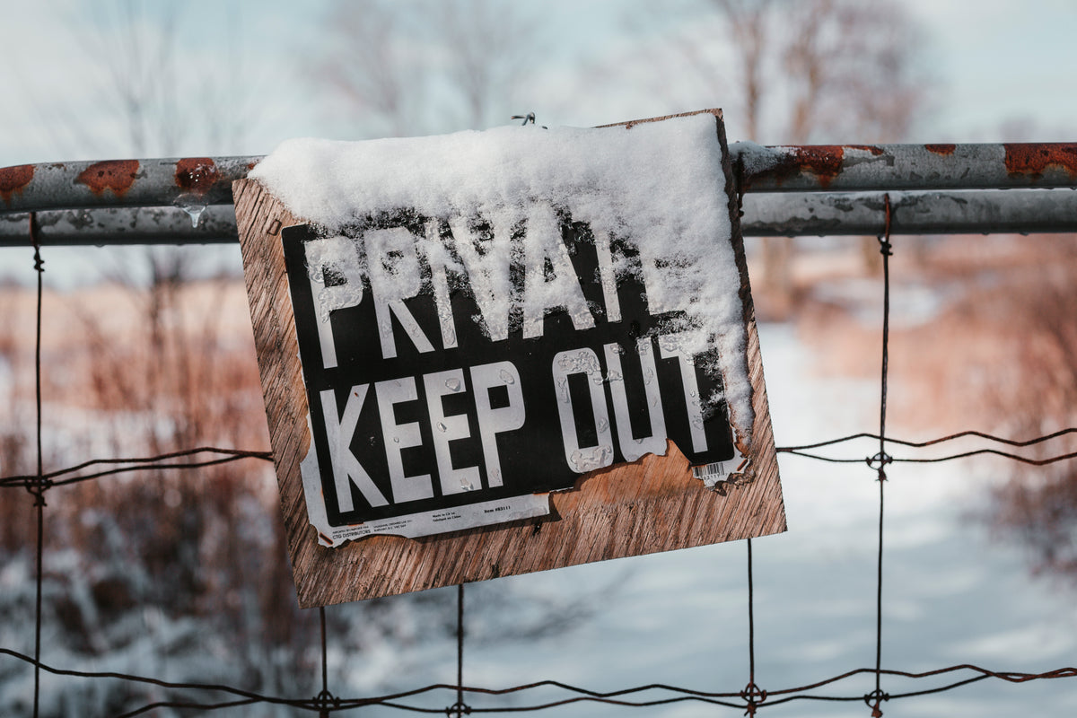 rustic snowy sign reads private keep out