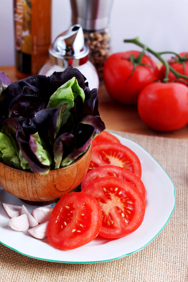 salad prep with tomatoes garlic and leaf lettuce