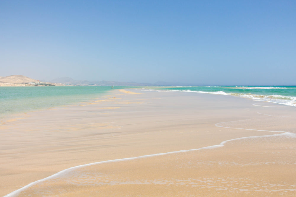 sand bar between blue ocean waters