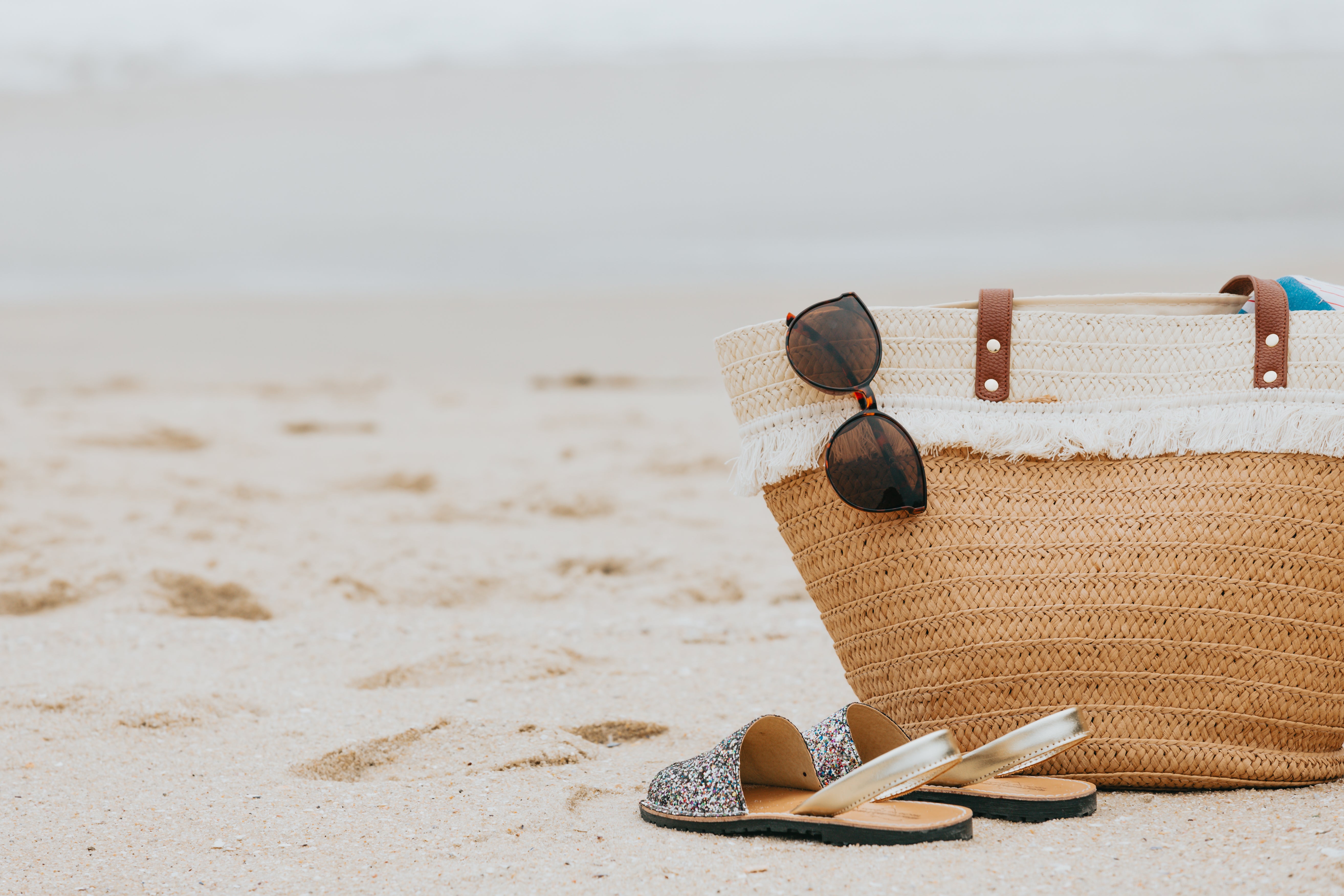 Summer beach bag with straw hat and sunglasses on sandy beach Stock Photo -  Alamy