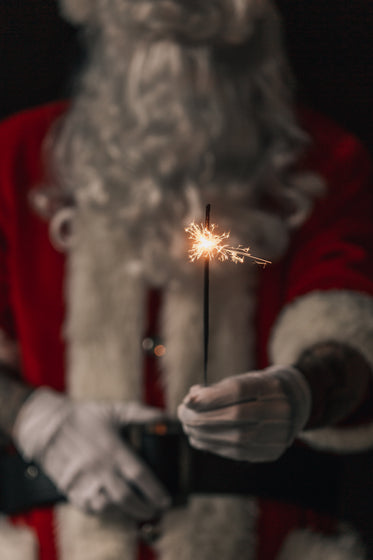 santa holds up sparkler