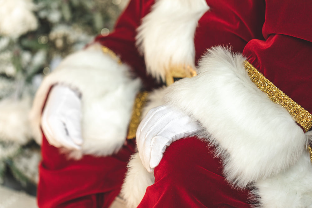 santa's white gloves and red velvet suit