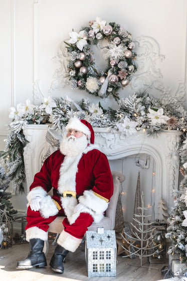 santa sits by the fireplace