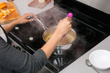 scooping soup on stove